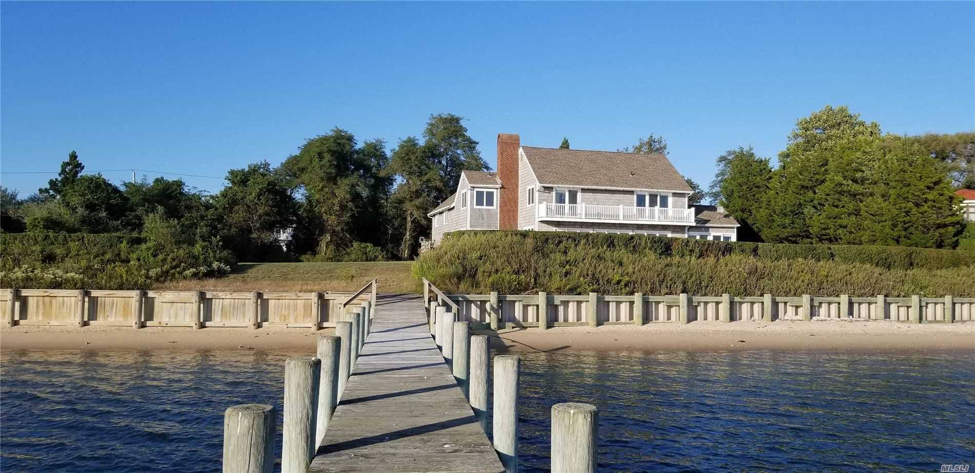 On Peconic Bay with 190 feet of waterfront with sandy beach, bulkhead and dock.