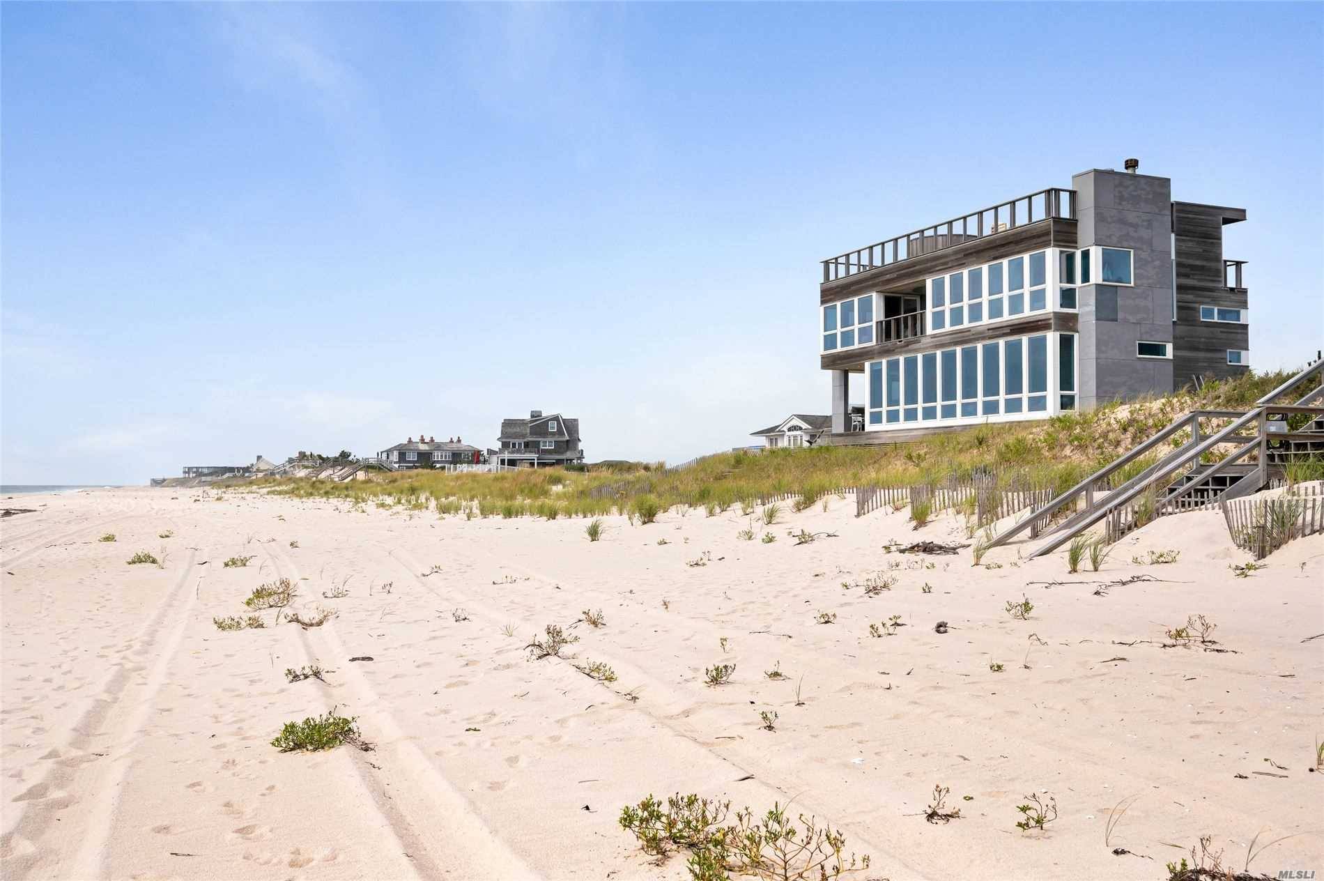 This property is spectacular, with 90 feet of ocean frontage, unobstructed views of Shinnecock Bay, and a chic, rooftop deck complete with fireplace and hot tub.