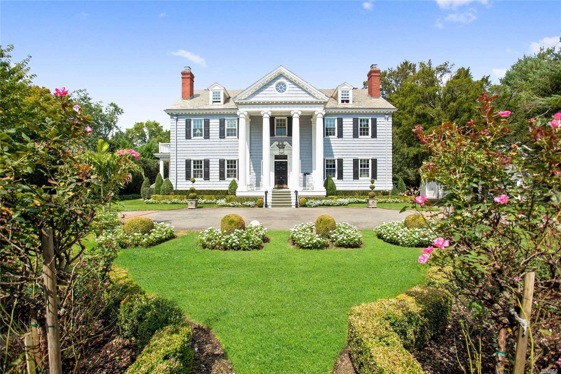 Behind the wall thru the gates is this extraordinary, 1913 center hall Georgian colonial offering the utmost in privacy, prominence prestige all within walking distance of town the LIRR.
