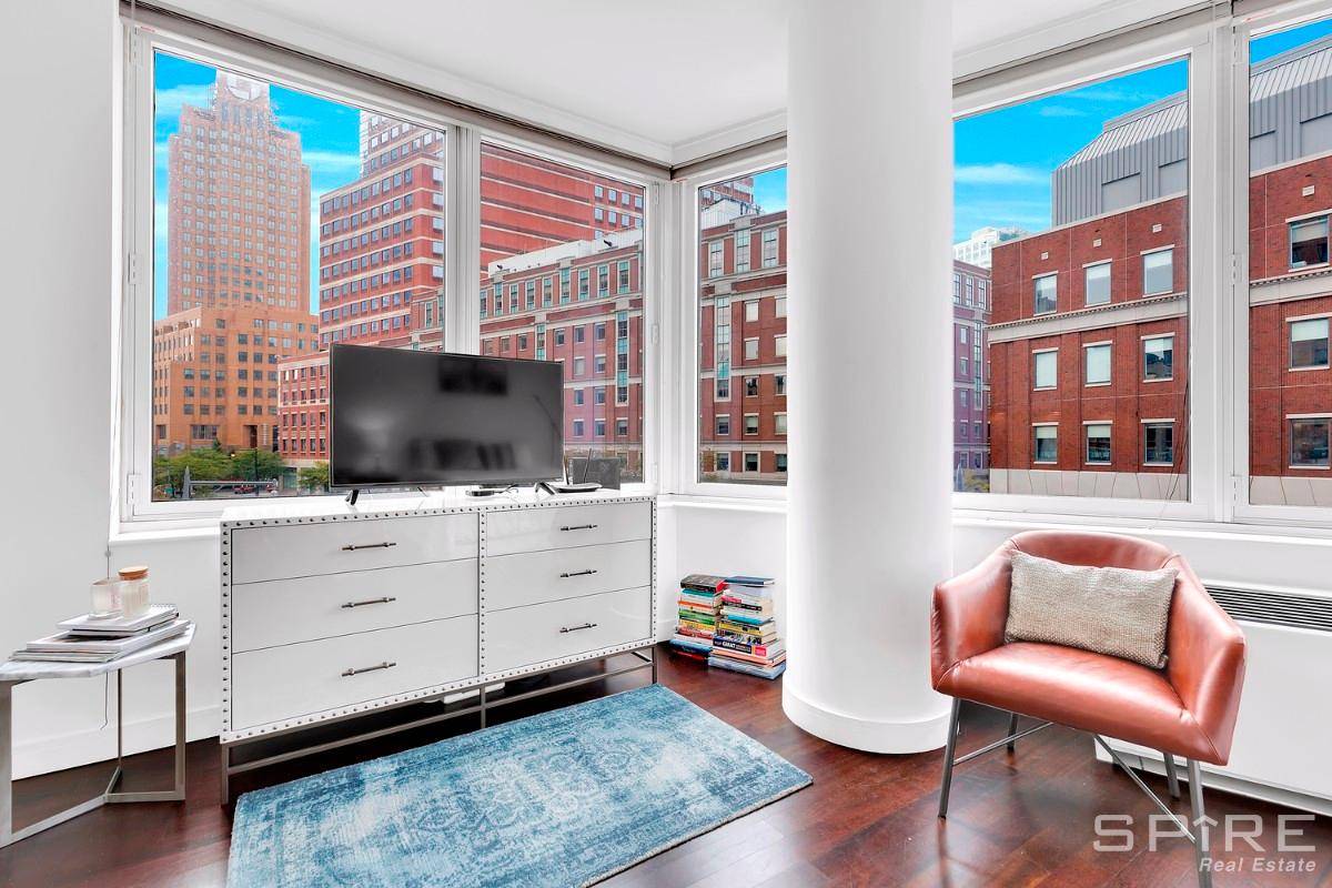 This lovely, modern studio apartment features a wall of windows, plenty of sunlight, and an open layout.