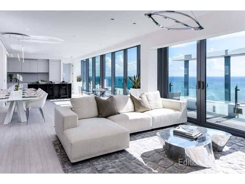 This exclusive waterfront penthouse features two-stories of ocean and bay views from all rooms through full floor-to-ceiling glass