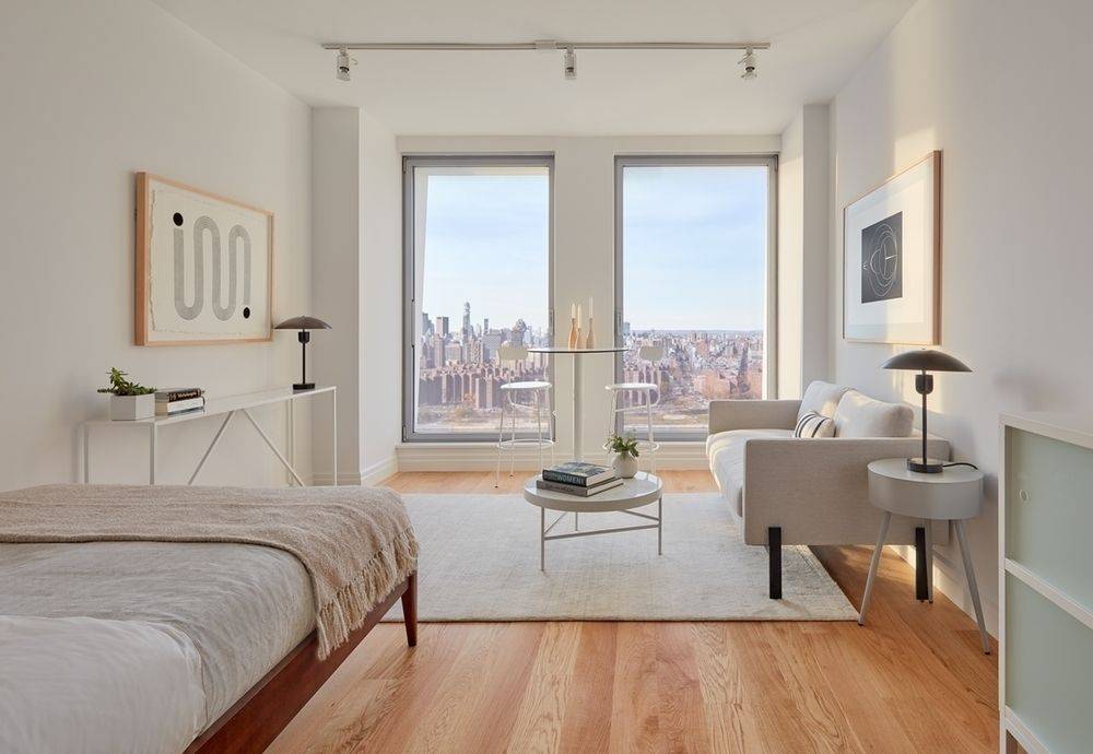 LUMINOUS WATERFRONT STUDIO WITH GORGEOUS VIEWS OF THE EAST RIVER, MANHATTAN SKYLINE, AND STATUE OF LIBERTY.