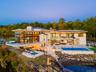 Back of property with a patio area, a swimming pool with hot tub, and a water view