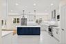 Bright formal dining area and kitchen transition layout, featuring premium quartz counters and open space with optional builder customization for arch