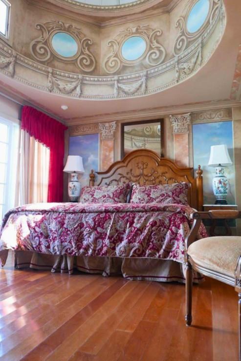 Bedroom featuring a high ceiling, wood finished floors, ornamental molding, and multiple windows