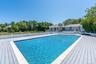 View of swimming pool with a patio area, a deck, and view of scattered trees