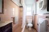Full bath with shower / tub combo with curtain, tile walls, vanity, and a wainscoted wall