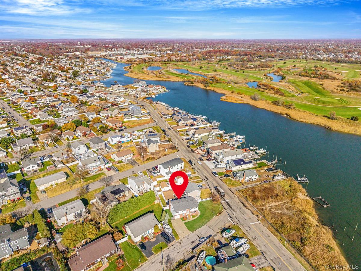 View of property location featuring nearby suburban area, a nearby body of water, and a golf course