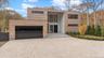 Contemporary home featuring gravel driveway and a garage
