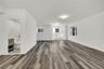 Unfurnished living room featuring dark wood-type flooring and baseboards