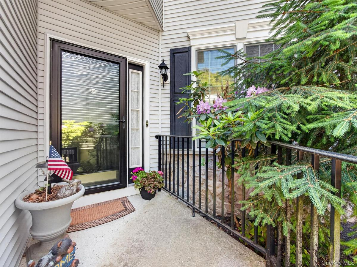Raised landing with stylish storm door and handrail.