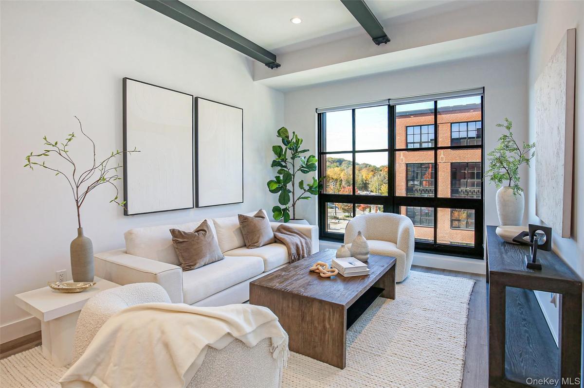 Living area with beam ceiling, wood finished floors, and recessed lighting