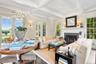 Living room with beamed ceiling, plenty of natural light, coffered ceiling, ornamental molding, and a fireplace