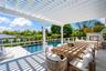 View of swimming pool featuring an outdoor stone fireplace, outdoor dining space, a pergola, and a patio
