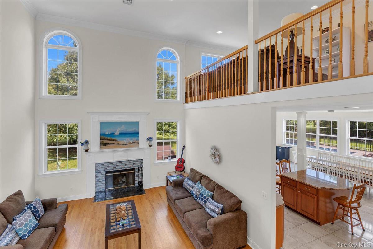 Two-story living room with soaring ceilings, arched transom windows, and abundant natural light