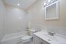 Bathroom featuring vanity, shower combination, tile walls, and recessed lighting