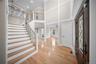 Entrance foyer featuring crown molding, a towering ceiling, a fireplace, light wood-style floors, and recessed lighting