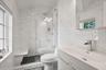 Bathroom with tile walls, vanity, and a stall shower