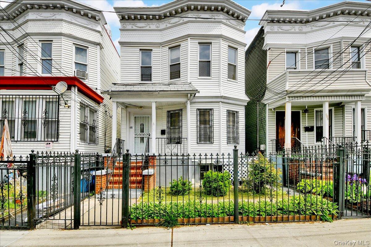 Two-story residence featuring white siding and bay windows on the upper level