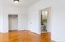 Room featuring wood-finish flooring, a built-in closet with bi-fold doors, and a ceiling-mounted light fixture