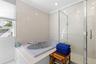 Bathroom with a shower stall, a jetted tub, tile walls, and ornamental molding