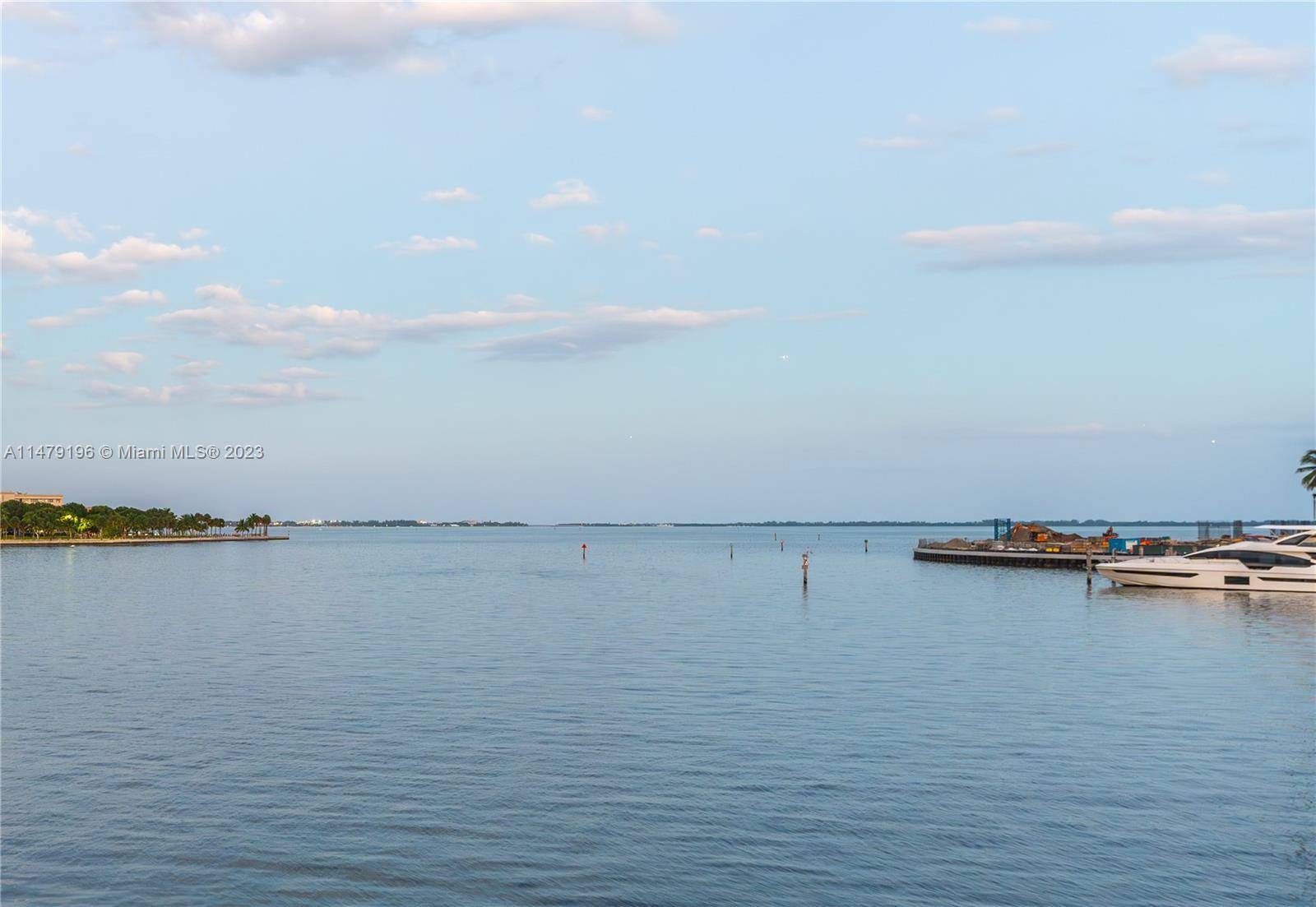 Coconut Grove bayfront with 139 ft of water frontage on a wide point lot w rare and substantive dockage.