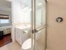 Ensuite bathroom with vanity, a stall shower, and light tile patterned flooring