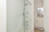 Full bath featuring baseboard heating and bath / shower combo with glass door