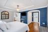 Bedroom featuring wood-finish flooring, a tray ceiling, and crown molding