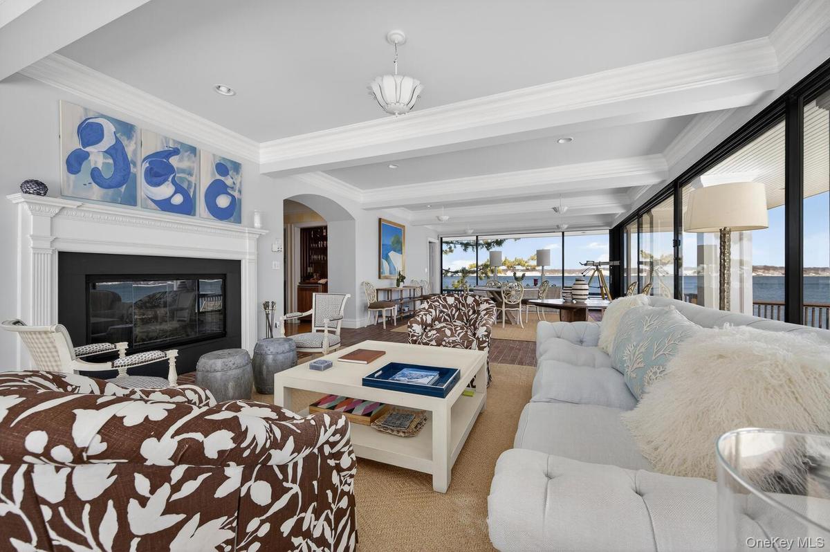 Large living/dining room with floor to ceiling doors and windows with water views
