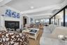 Large living/dining room with floor to ceiling doors and windows with water views