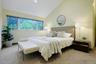 One of three generously sized bedrooms in the kids' wing, offering peaceful treetop views and ample closet space.