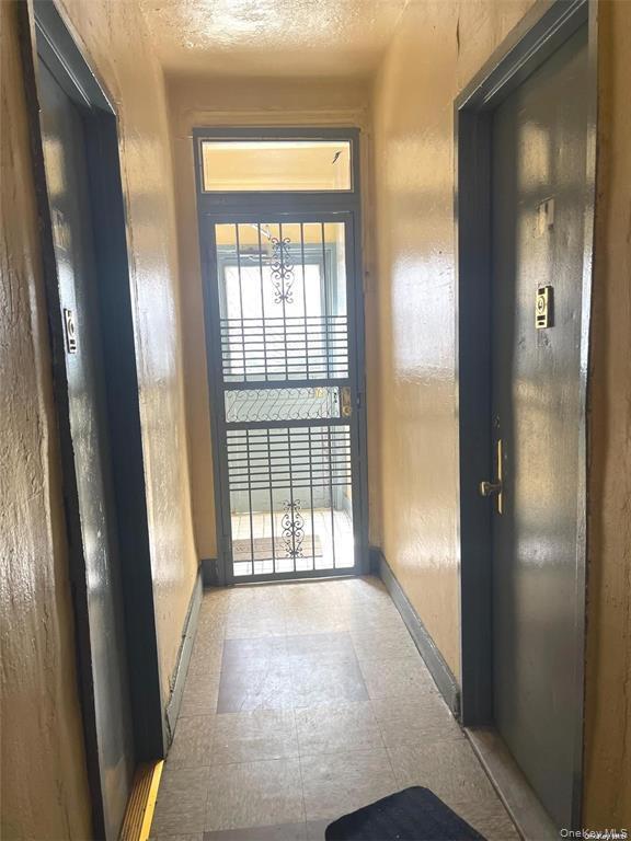 Hall featuring tile patterned floors and baseboards