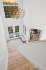 Staircase with a high ceiling, french doors, wood finished floors, and a chandelier