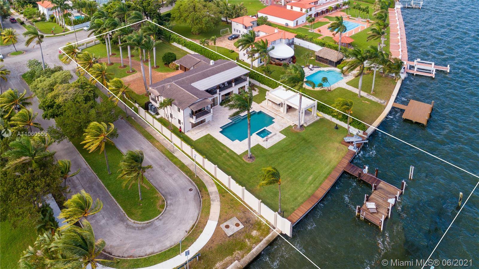 Majestic Estate located in Historic Morningside on a gated 30, 100 SF corner lot surrounded by lush greenery, manicured lawns and 100ft of wide bay waterfront.