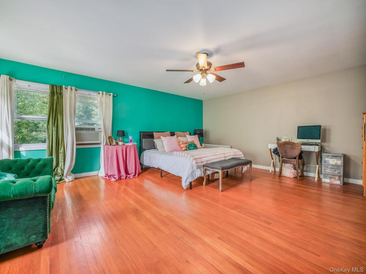 Bedroom featuring light wood finished floors, a ceiling fan, and cooling unit