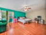 Bedroom featuring light wood finished floors, a ceiling fan, and cooling unit