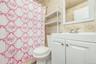 Bathroom featuring tile walls, vanity, shower / tub combo with curtain, and decorative backsplash