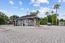 Guard-gated community entrance with pavered drive and secure access.