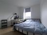 Bedroom with wood finished floors and baseboards