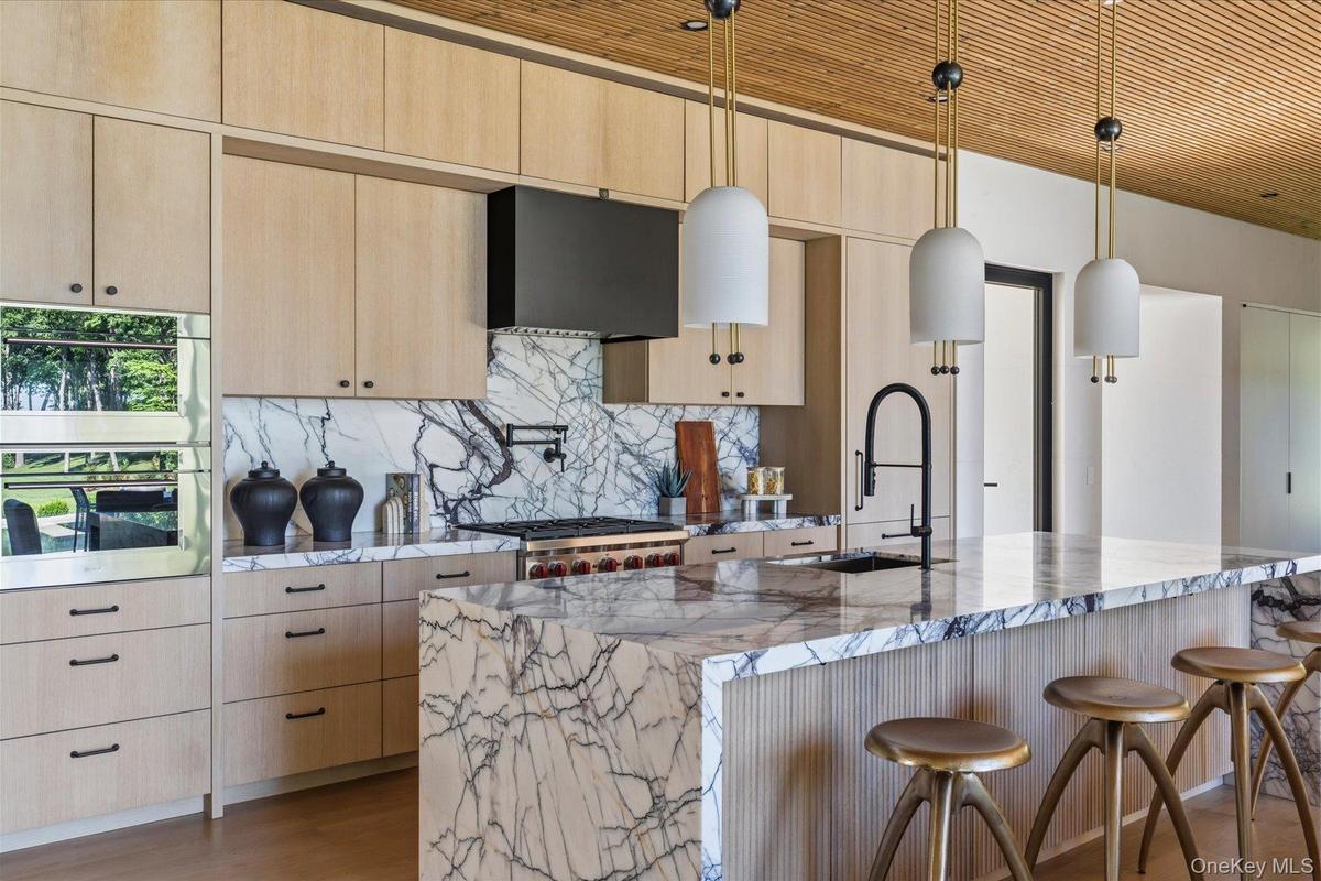 Chef’s kitchen with oversized lilac marble island and custom cabinetry