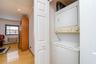 Washroom with stacked washer and clothes dryer, light wood-type flooring, ornamental molding, recessed lighting, and a textured ceiling