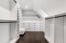 Walk in closet with dark wood finished floors