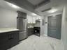 Kitchen with appliances with stainless steel finishes, modern cabinets, white cabinets, and light marble finish floors