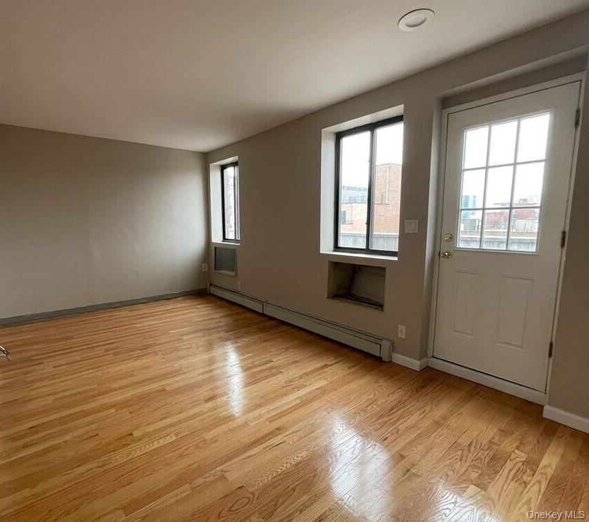 Entryway featuring a baseboard radiator and wood finished floors