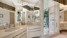 His-and-Her sinks, paired with a glass-enclosed luxury shower featuring dual shower heads