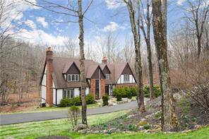 Classic Tudor Style Colonial in spectacular, private setting offering distant woodland views scenic meandering brook.