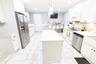 Kitchen with a kitchen island, stainless steel appliances, white cabinetry, hanging light fixtures, and crown molding