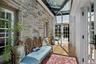 This thoughtfully designed glass-enclosed passage preserves the original stone wall while dramatic skylights flood the space with natural light, creat