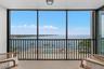Screened terrace overlooking the bay-side heated community pool, private fishing pier, and open water of Tampa Bay.